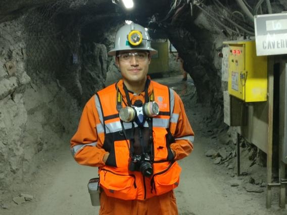 miner in orange gear with a helmet and ventilator